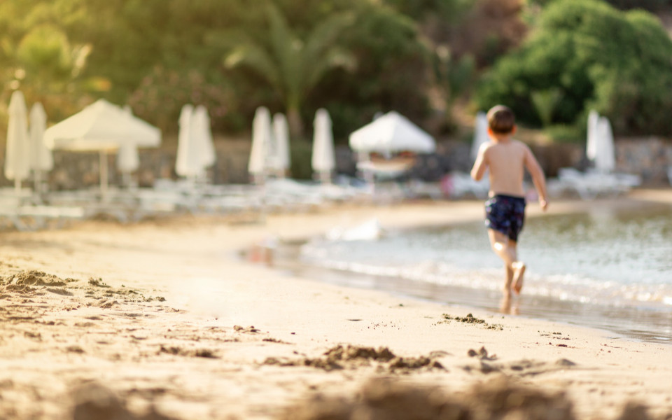 Junge l&auml;uft am Sandstrand entlang