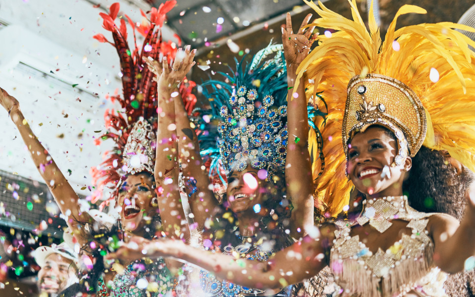 Schnappschuss sch&ouml;ner Samba-T&auml;nzer, die mit ihrer Band auf einem Karneval auftreten.