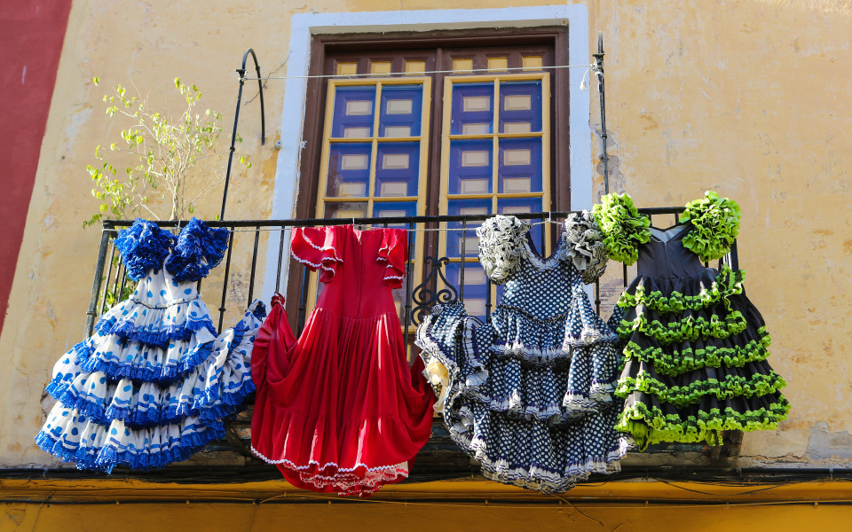 Bunte Flamenco-Kleider h&auml;ngen von einem Balkon in Andalusien