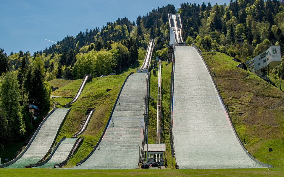 Die Olympiaschanze in Garmisch-Partenkirchen mit mehreren Skisprungschanzen nebeneinander.