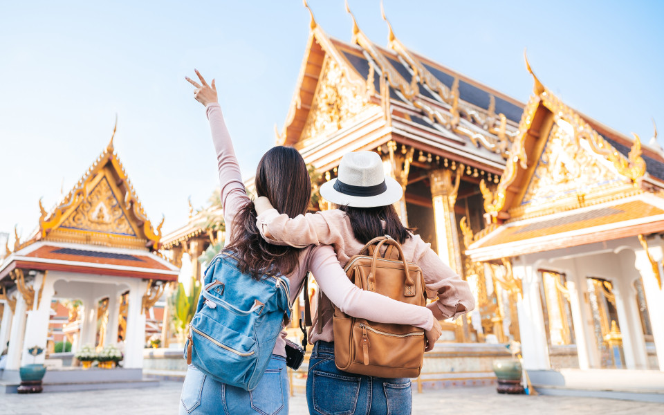 Zwei gl&uuml;ckliche Reisende an einem Tempel in Thailand